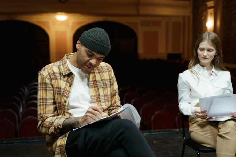 Man In Plaid Shirt Writing On A Paper